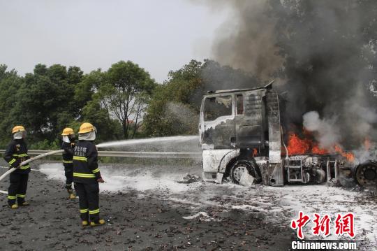 攝消防官兵利用泡沫水槍對車頭實施撲救。　王基達 攝