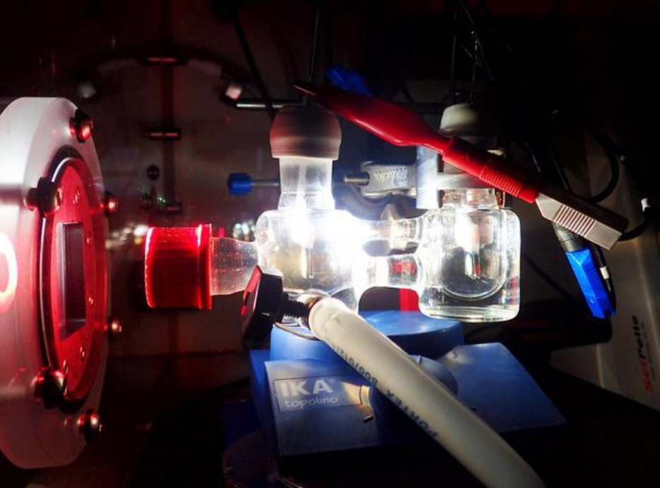 圖中是雙電極裝置實驗,展示了使用模擬太陽光照射的光電化學電池 圖中是雙電極裝置實驗,展示了使用模擬太陽光照射的光電化學電池